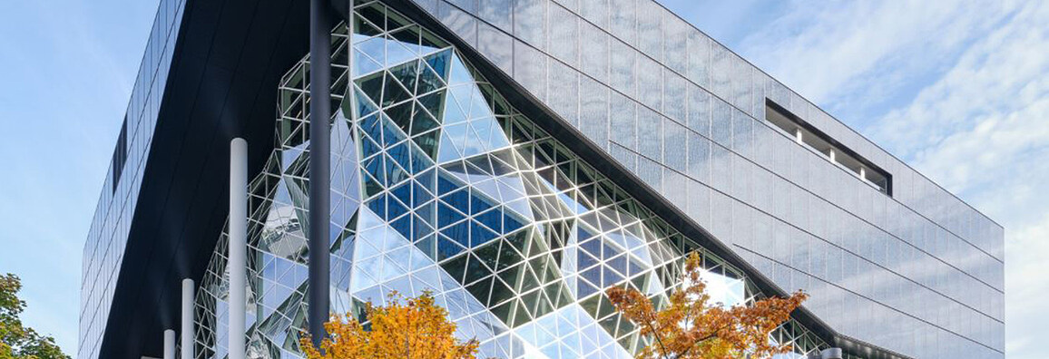 Innovative building with an acute-angled façade structure and prism-shaped glass elements