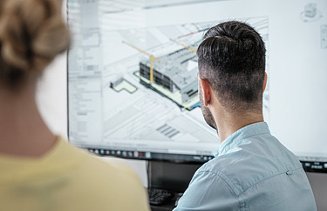 People look at a screen with a construction plan