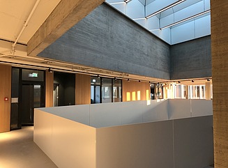 Office building with structured façade, tall narrow windows and entrance area with columns