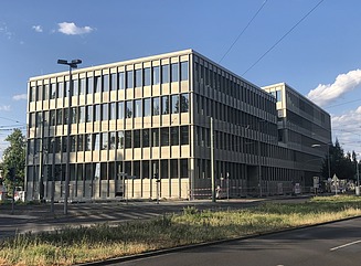 Office building with structured façade, tall narrow windows and entrance area with columns